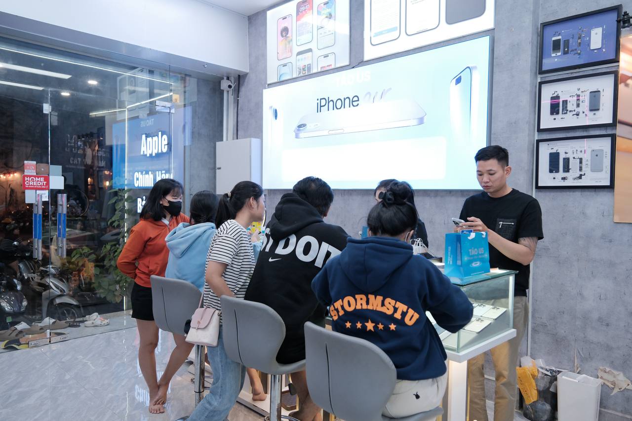 Nhân viên và khách trao đổi về cam kết khi mua iPhone