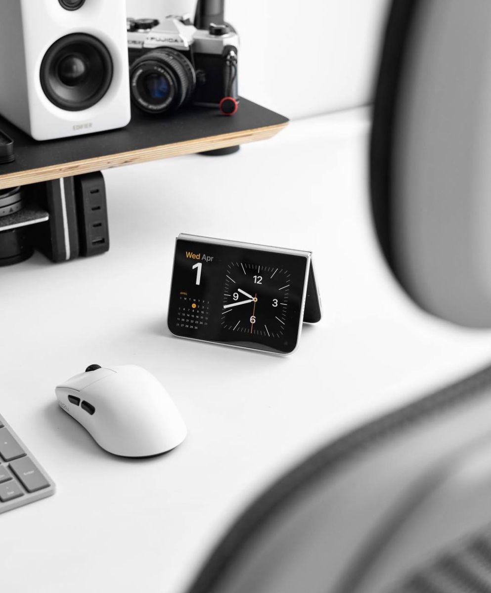 Màn hình ngoài hiển thị đồng hồ của iPhone Duo trên bàn làm việc